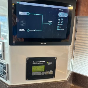 Marine generator control panel with digital display and buttons.