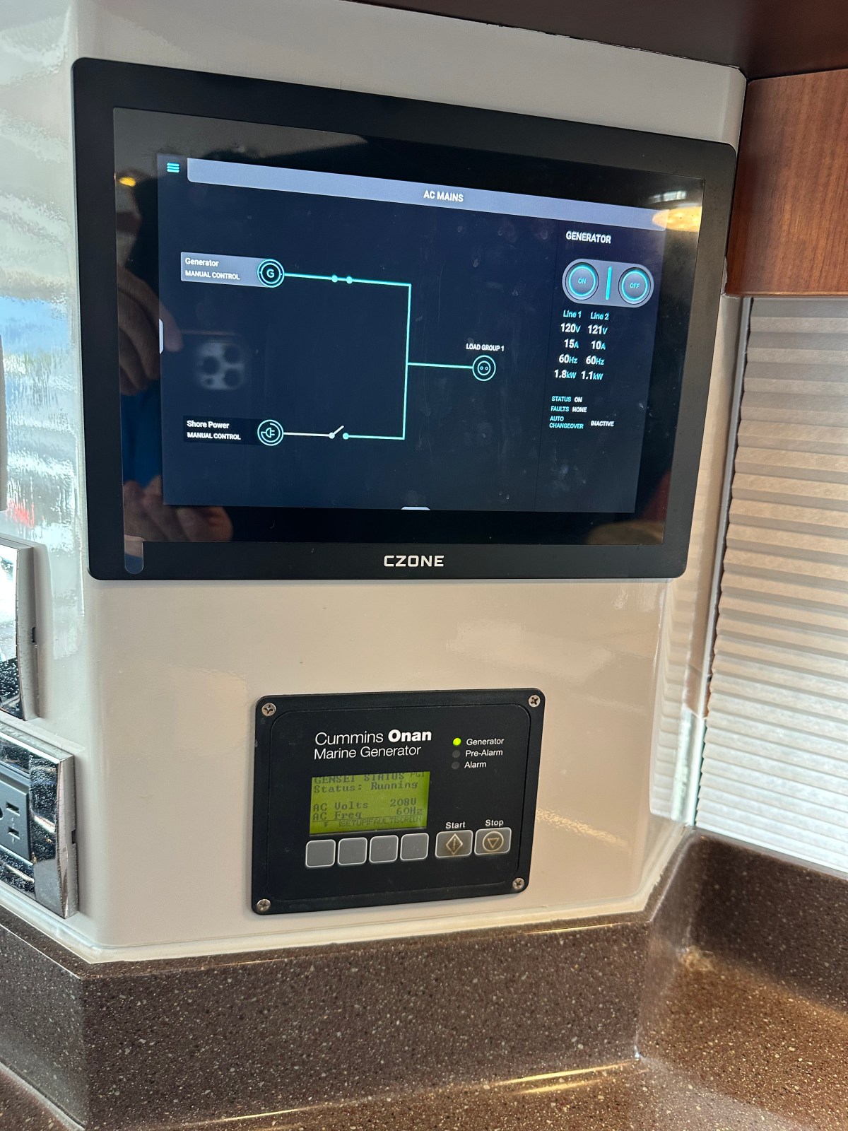 Marine generator control panel with digital display and buttons.