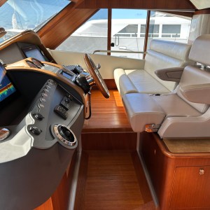 Luxurious yacht cockpit with leather seats, wooden panels, and navigation controls.