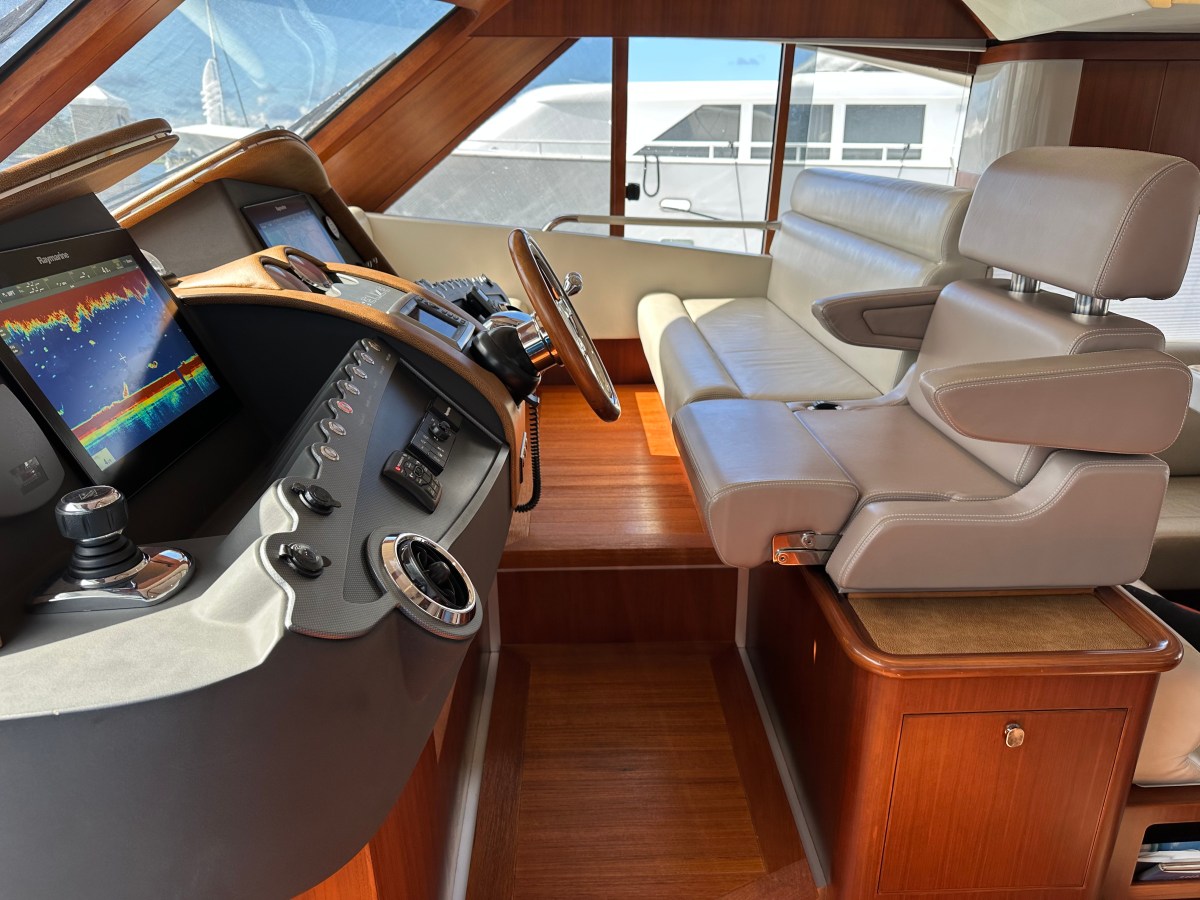 Luxurious yacht cockpit with leather seats, wooden panels, and navigation controls.