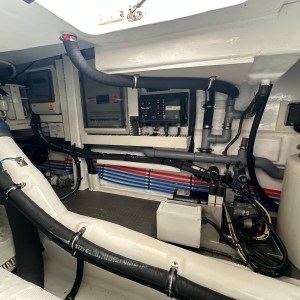 Interior of a boat's engine room with pipes and control panels visible.